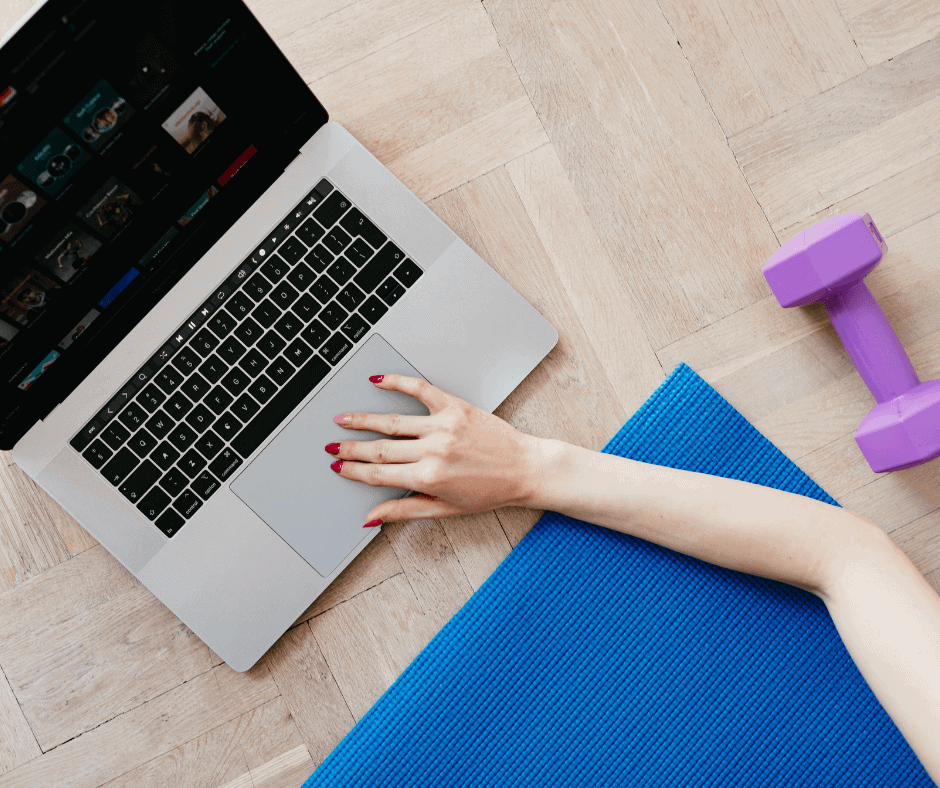 woman with laptop on the floor working out at home 